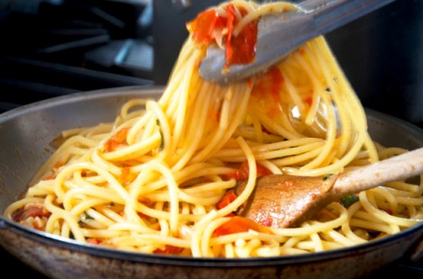 Amatriciana tossing bucatini in sauce